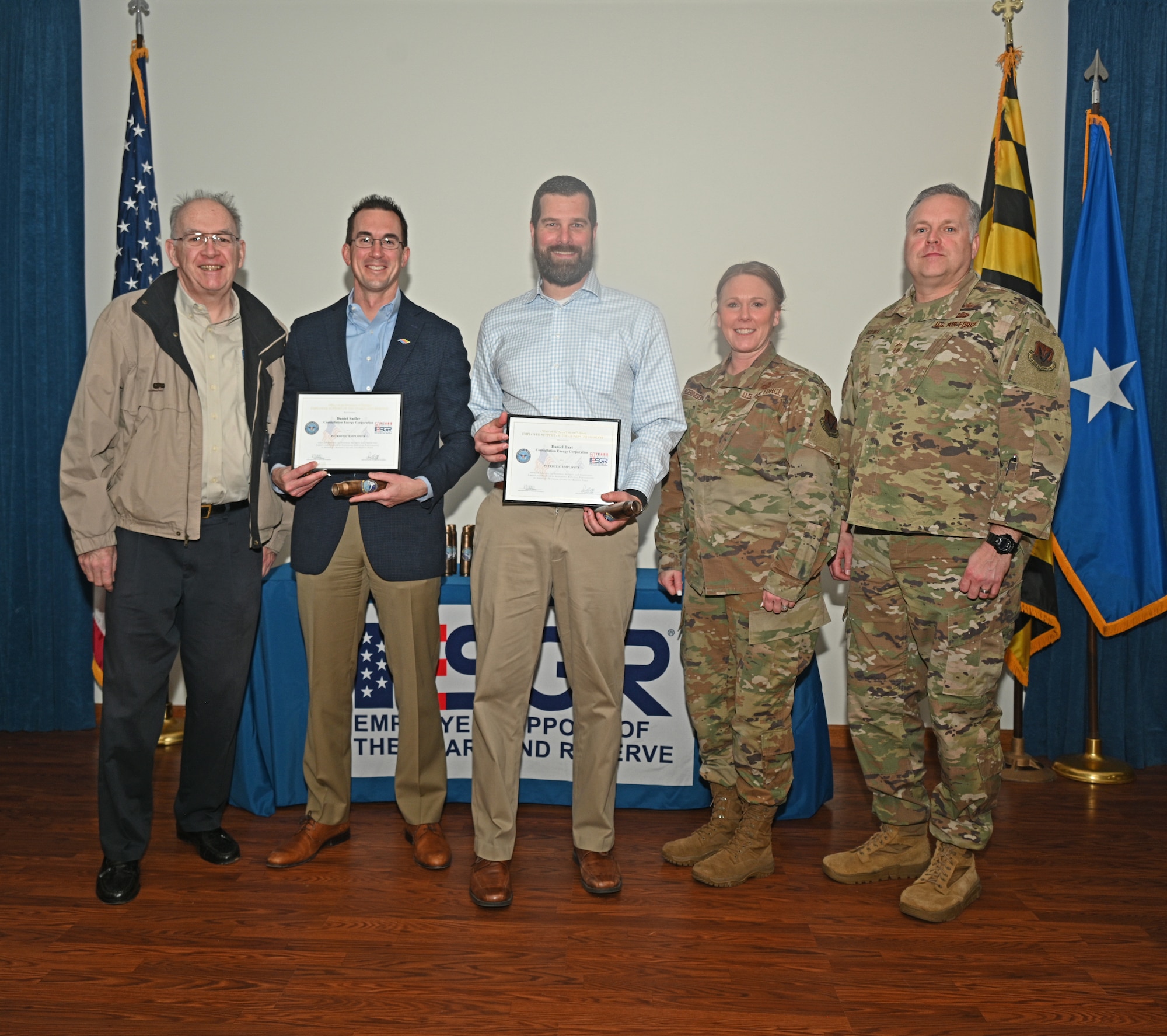 U.S. Air Force Brig. Gen. Jori Robinson (2nd from right), 175th Wing commander, and U.S. Air Force Senior Master Sgt. Scott Howe (right), 275th Cyberspace Operations Squadron, present the Patriot Award to Howe's civilian employers at Martin State Air National Guard Base, Middle River, Md., March 24, 2023.