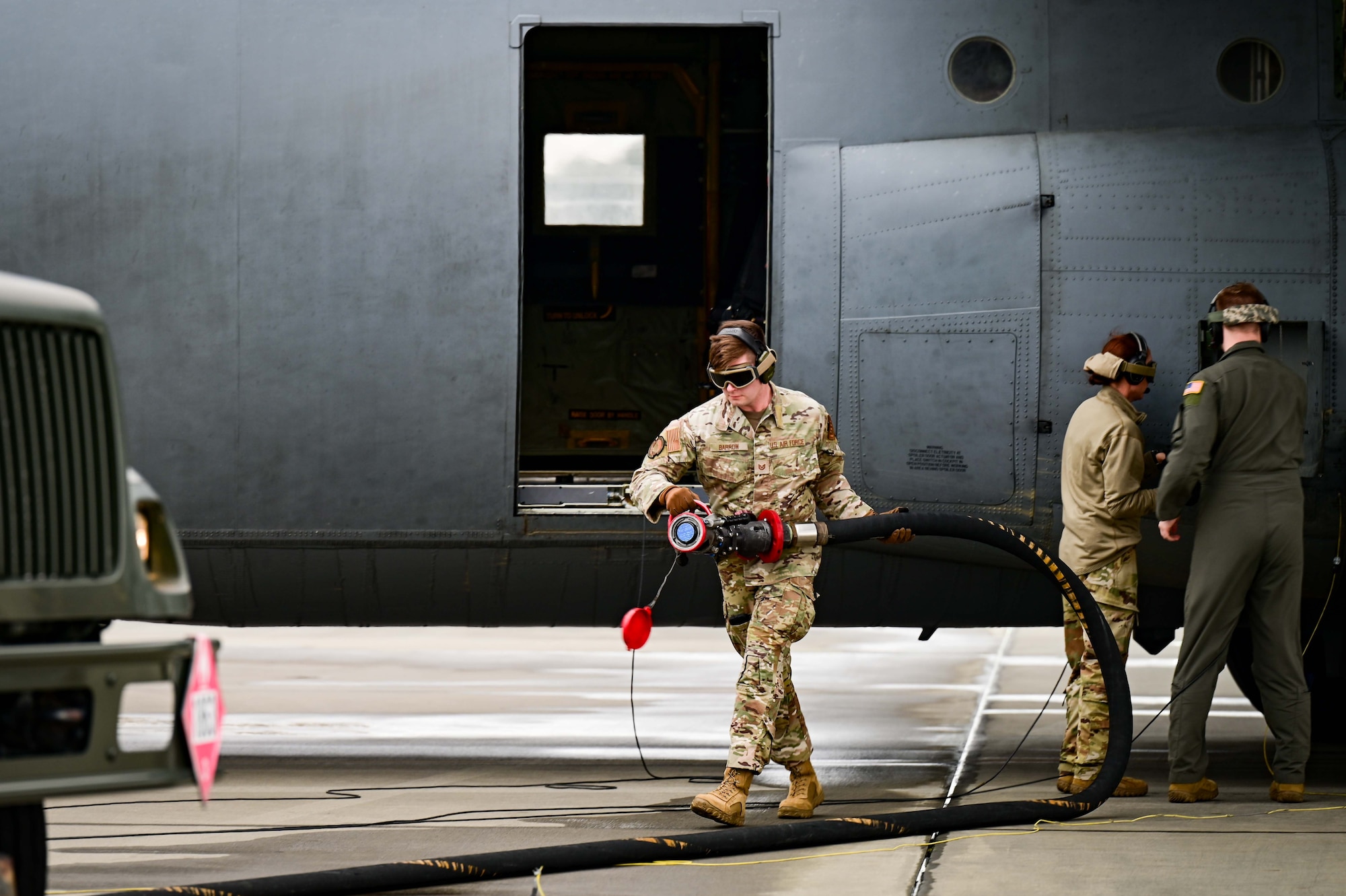 A C-130J Cargo plane fuels an F-35 Fighter jet on the flightline