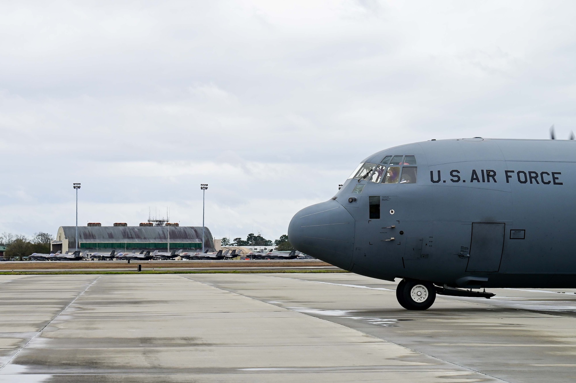 A C-130J Cargo plane fuels an F-35 Fighter jet on the flightline