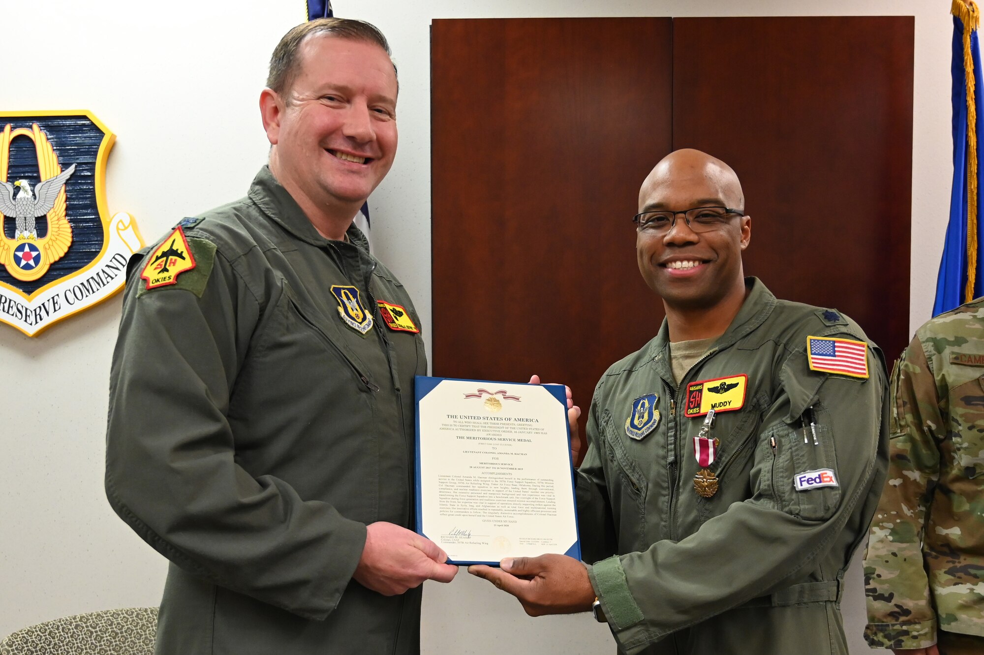 two men holding a certificate and smiling at the camera