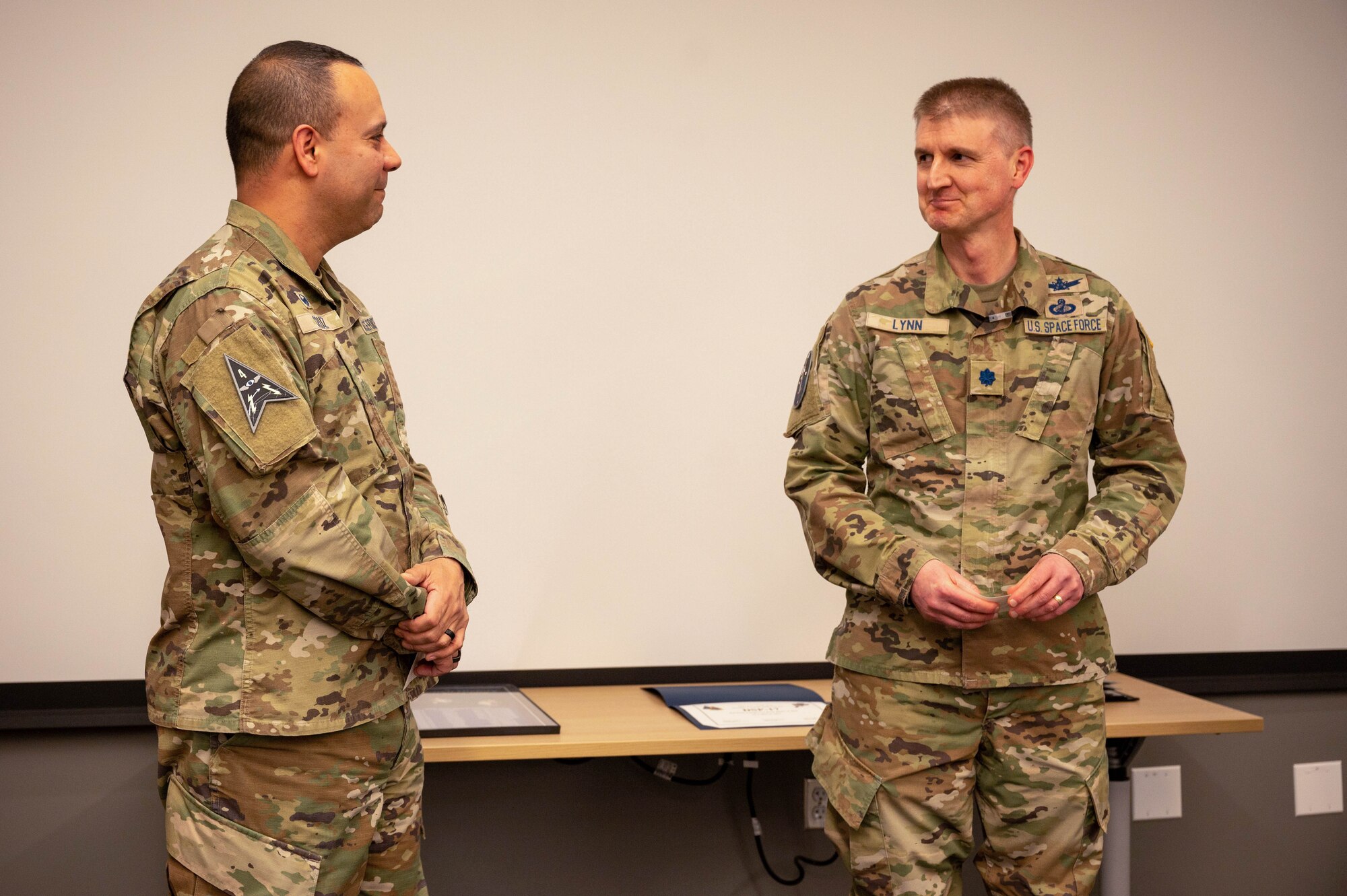 U.S. Space Force Col. Miguel Cruz, Space Delta 4 commander, alongside U.S Space Force Lt. Col. Michael Lynn, Space Operations Command Missile Warning/Missile Tracking Integration Branch chief, offer remarks on a Defensive Support Program satellite at Buckley Space Force Base, Colo., March 2, 2023. The Space Delta 4 team, comprised of Guardians, Airmen, and civilians of all age ranges, alongside mission partners from the United Kingdom, Australia, and Canada, celebrated the retirement of the DSP satellite. (U.S. Space Force photo by Airman 1st Class Shaun Combs)