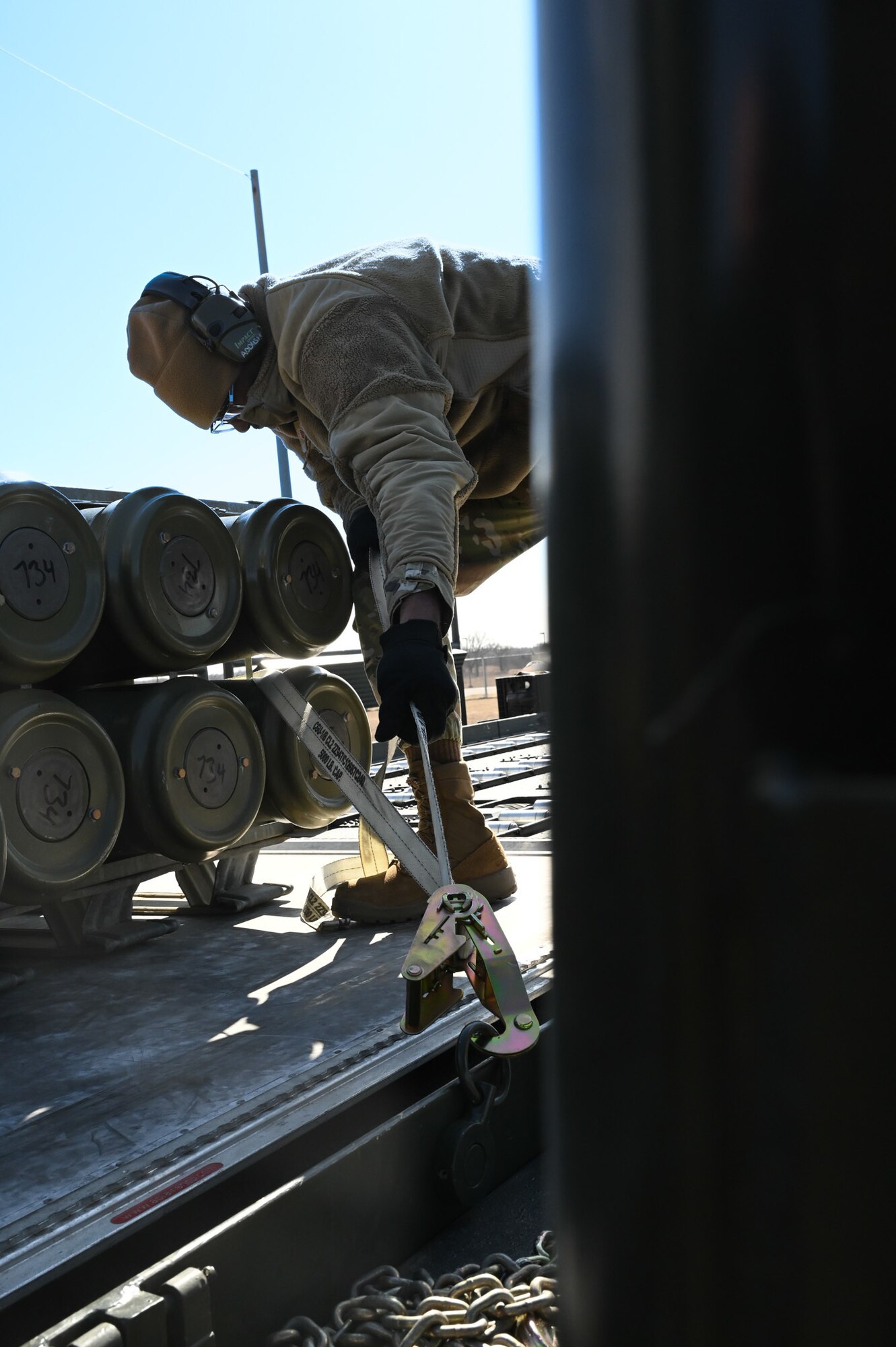 man tying down munitions