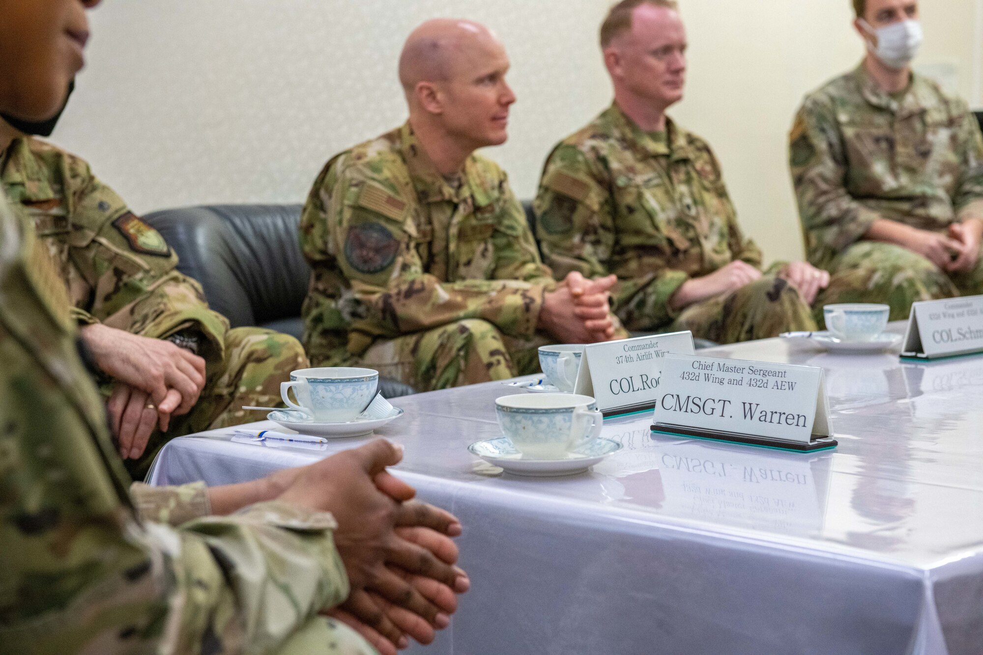 A nameplate sits on a table during a meeting