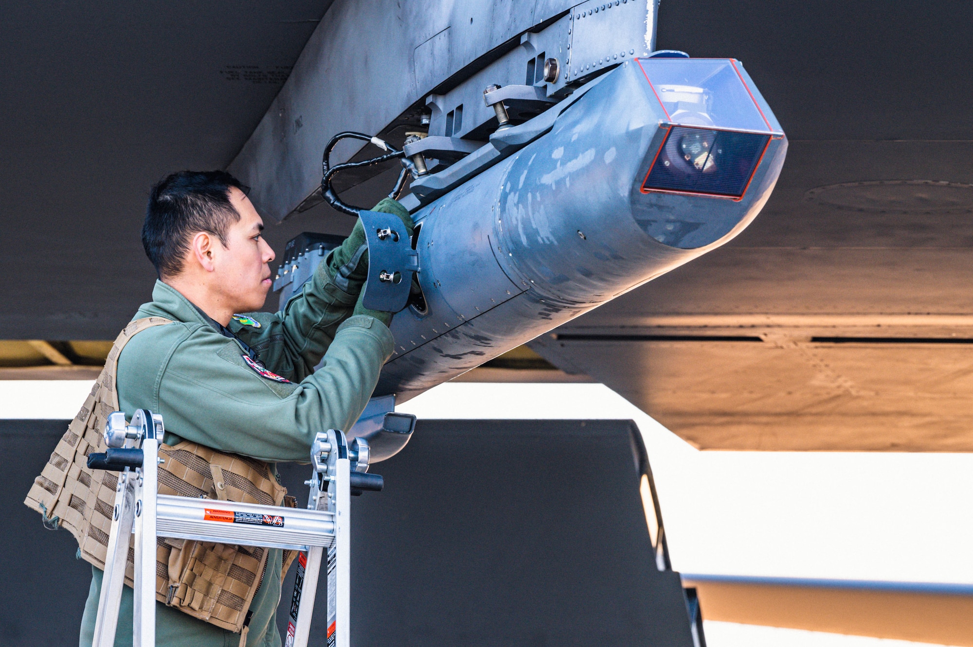 Capt. Angelico Palparan, weapon system officer assigned to the 23rd Expeditionary Bomb Squadron, inspects a B-52H Stratofortress targeting pod before takeoff at Morón Air Base, Spain, Mar. 1, 2023. Strategic bomber missions enhance the readiness and training necessary to respond to any potential crisis or challenge across the globe. (U.S. Air Force photo by Airman 1st Class Alexander Nottingham)
