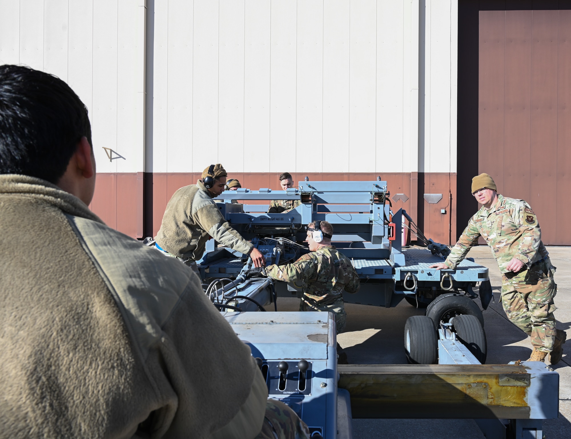 Airmen assigned to the 509th Aircraft Maintenance Squadron perform training on the launcher load system at Whiteman Air Force Base, Missouri, Feb. 2, 2023. The airmen connect the launcher load system adaptor to the jammer in preparation to download the rotary launcher assembly. (U.S. Air Force photo by Airman 1st Class Hailey Farrell)