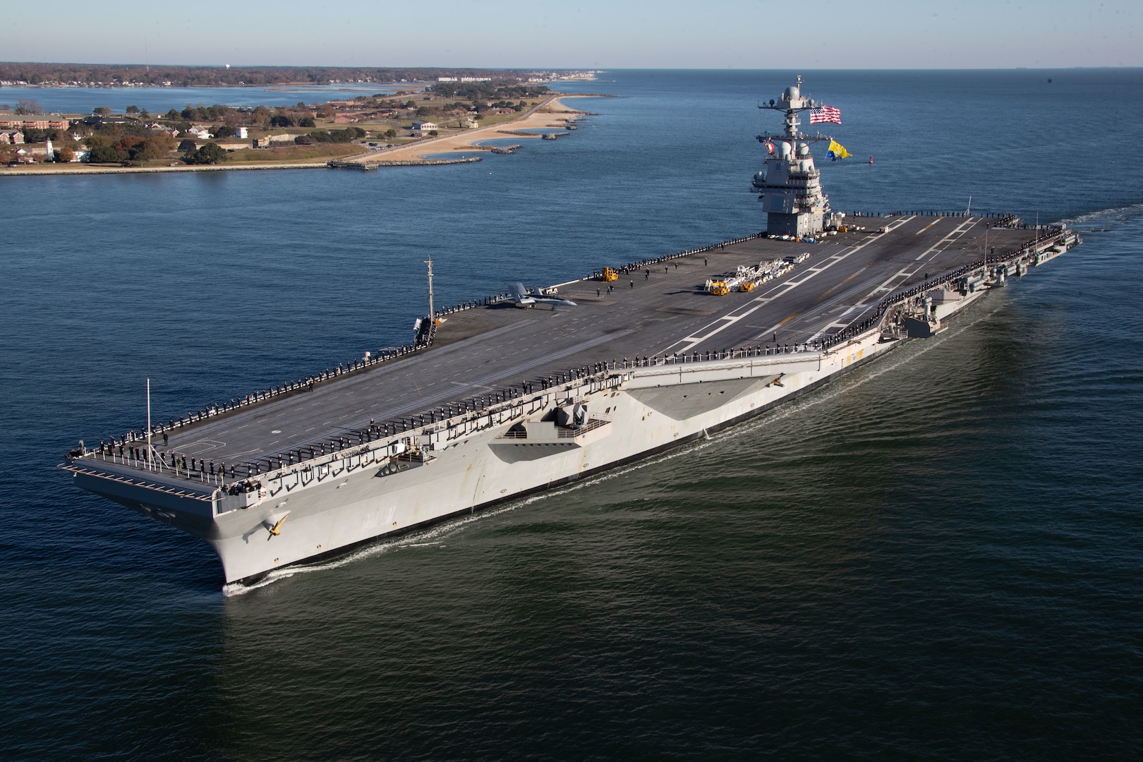 The crew of the first-in-class aircraft carrier USS Gerald R. Ford (CVN 78) man the rails as the ship returns to Naval Station Norfolk, Nov. 26, following the inaugural deployment with the Gerald R. Ford Carrier Strike Group (GRFCSG).