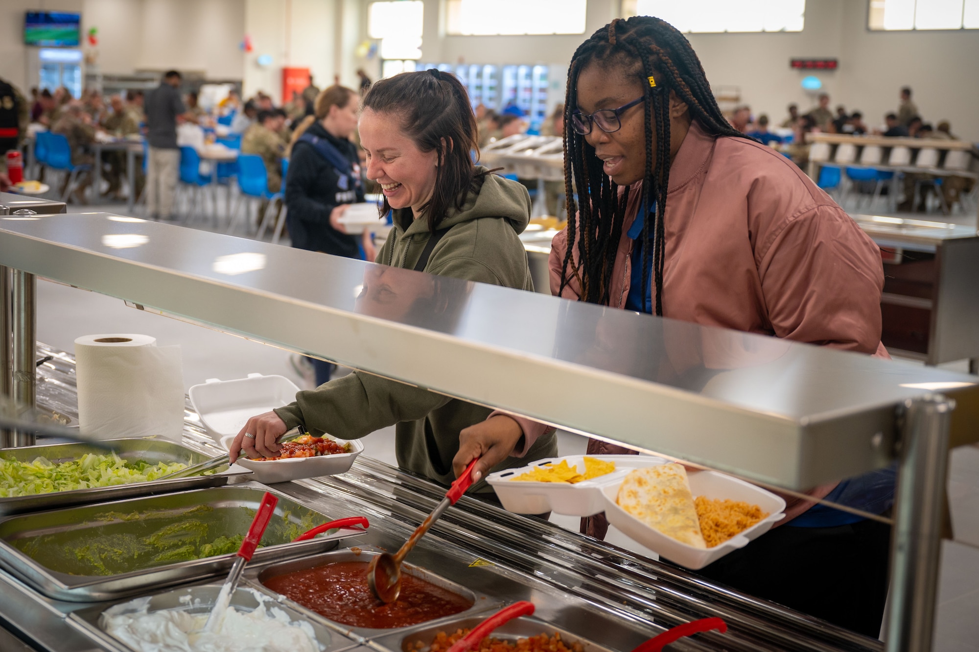 Two people get food at the Pearl dining facility.