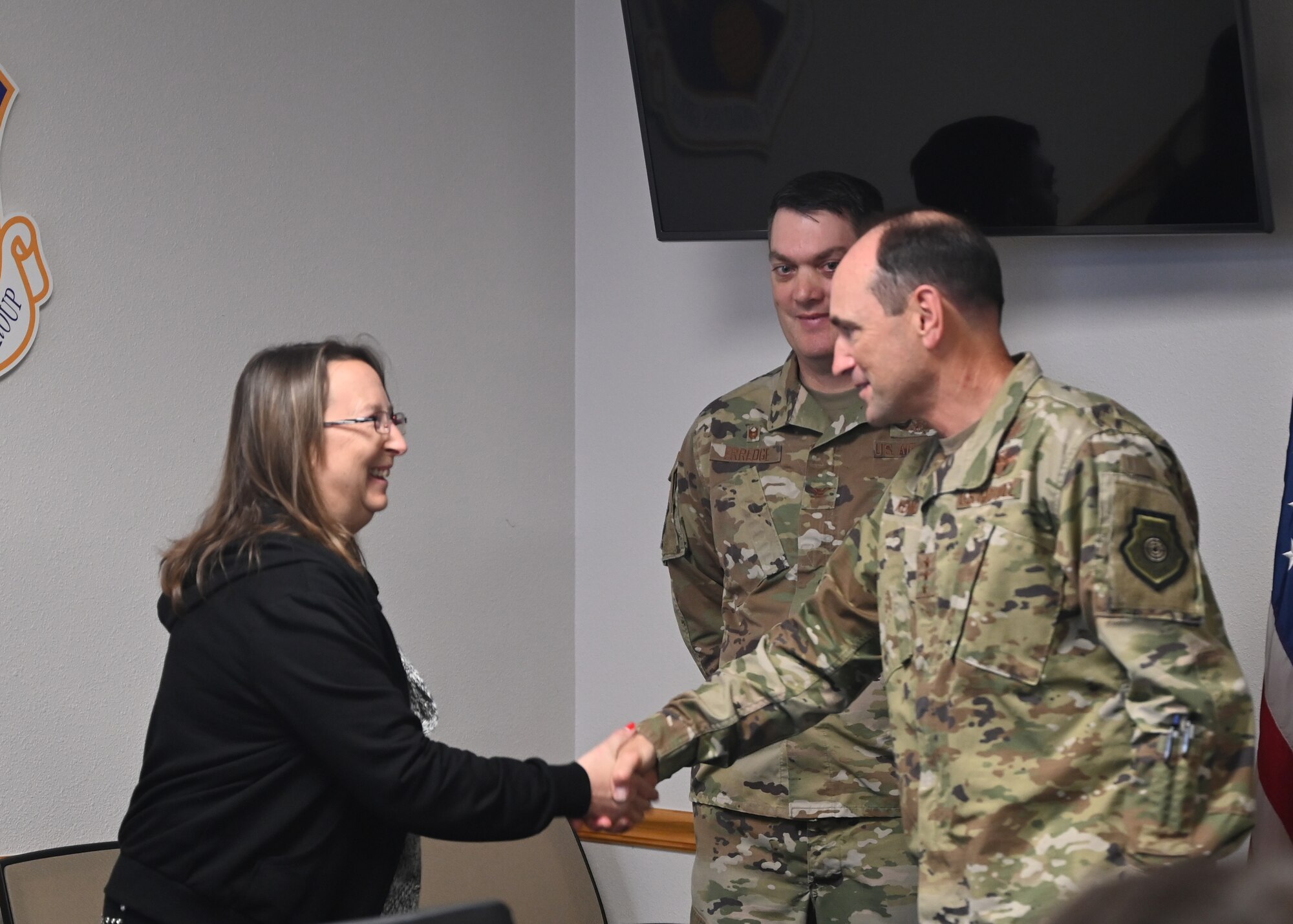 Lee Traxler, unit deployment manager for the 960th Cyberspace Wing, is presented a coin by Lt. Gen. Kevin B. Kennedy.