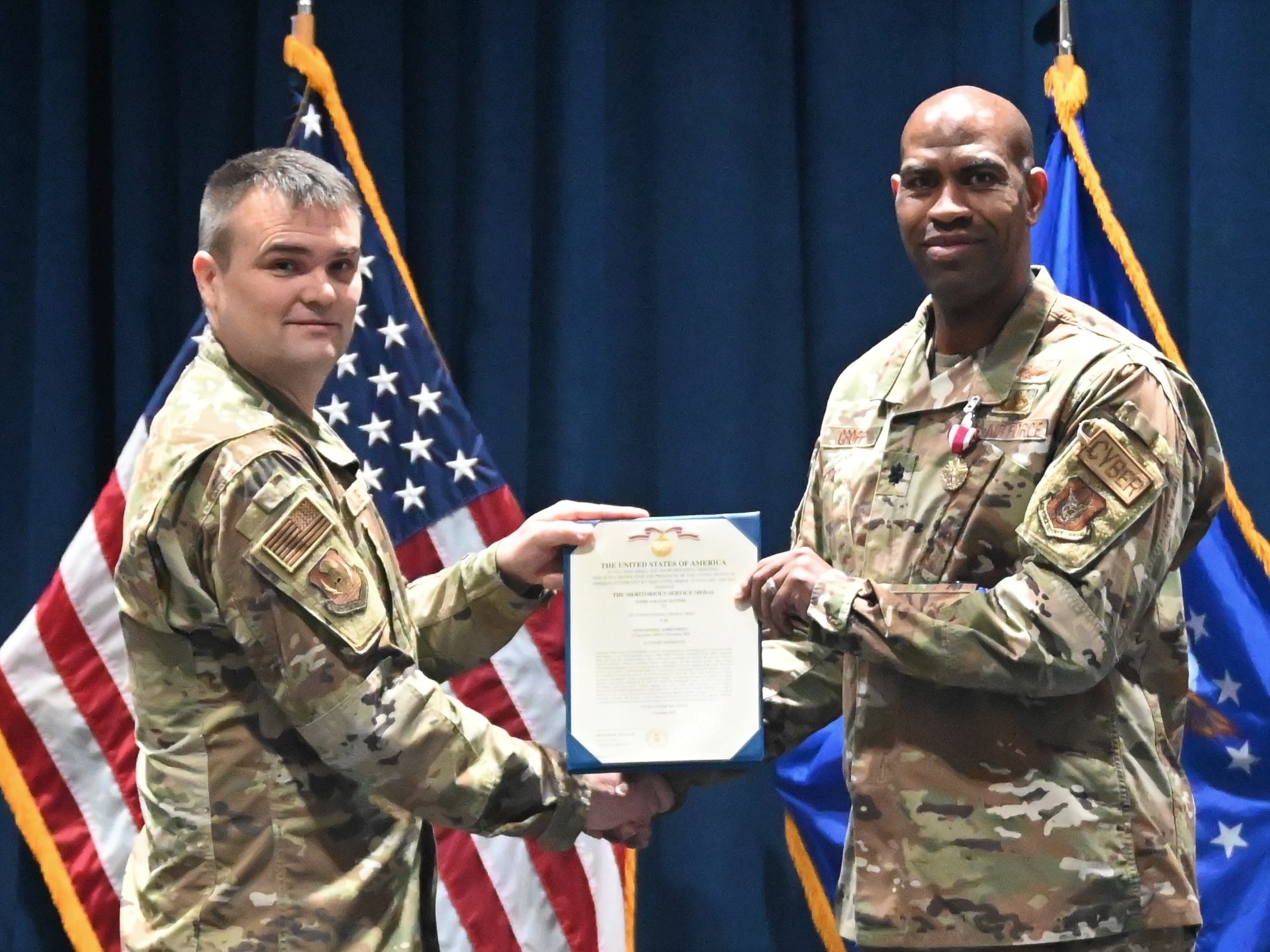 Col. Richard Wallace, 960th Cyber Operations Group commander, presents the Meritorious Service Medal to Lt. Col. Jarvis Croff, outgoing commander of the 960th Operations Support Flight.