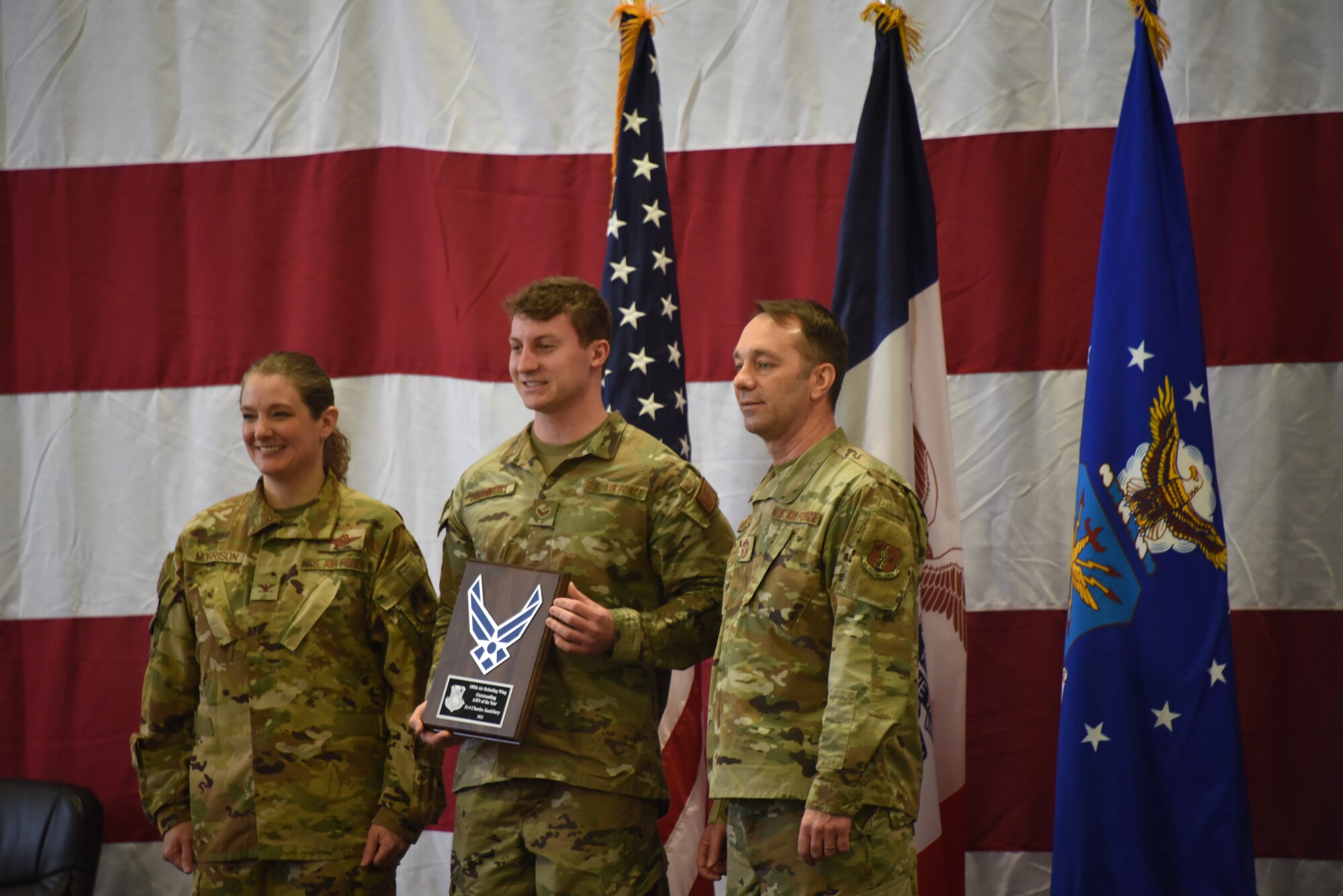 Senior Airman Charles Saulsbury poses for photo with plaque.