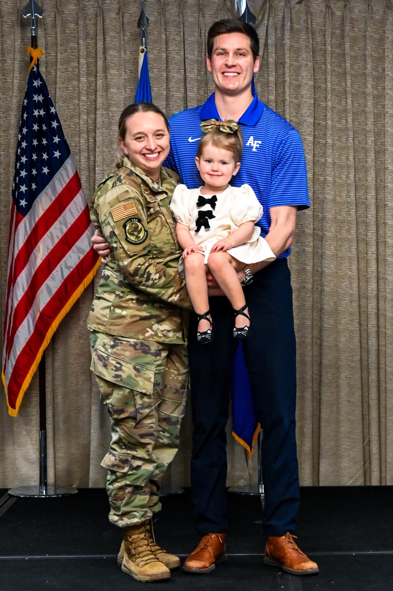 airman posing with spouse and toddler