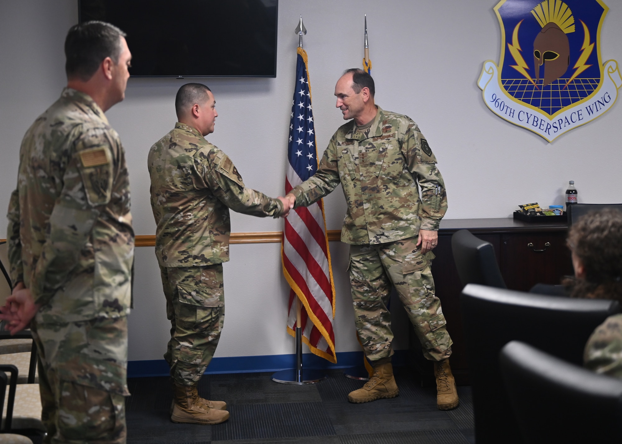 Lt. Gen. Kevin B. Kennedy presents TSgt Rene J. Riojas a coin for his tenure as commander’s support staff for the 960th Cyberspace Wing.