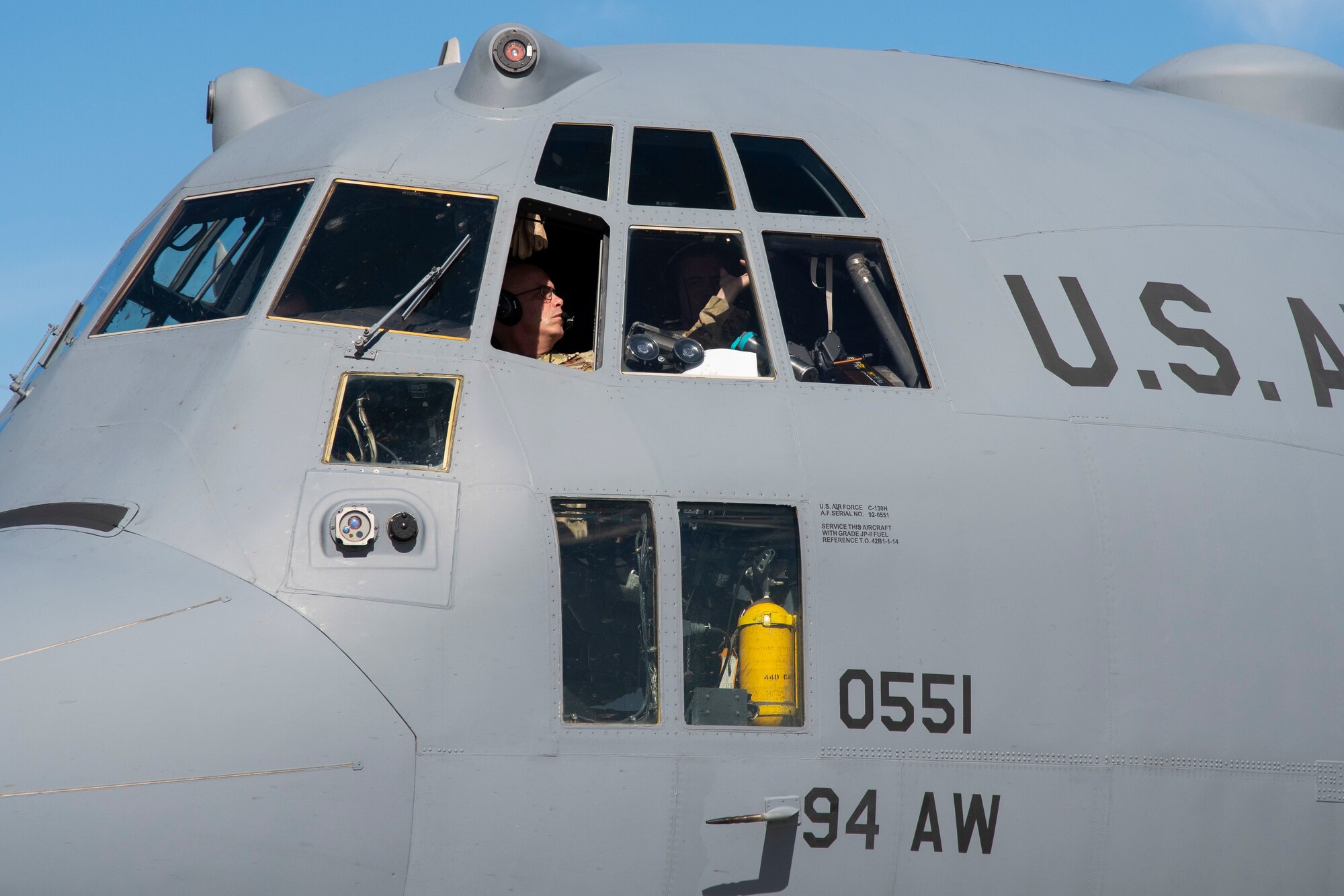 A man turns off an airplane inside of the cockpit.