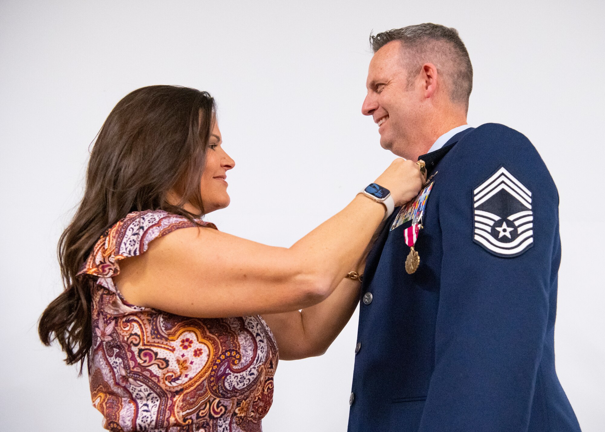 Kimberly Yoder pins a retirement pin onto her husband, Chief Master Sgt. Scott E. Yoder.