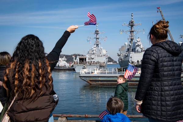 Family members of Sailors assigned to the Arleigh Burke-class guided-missile destroyer USS John Finn (DDG 113) cheer as Finn arrives at Commander Fleet Activities Yokosuka (CFAY). Finn arrives from Naval Base San Diego to CFAY, becoming the latest forward-deployed asset in the U.S. 7th Fleet. For 75 years, CFAY has provided, maintained, and operated base facilities and services in support of the U.S. 7th Fleet's forward-deployed naval forces, tenant commands, and thousands of military and civilian personnel and their families. (U.S. Navy photo by Mass Communication Specialist 1st Class Kaleb J. Sarten)