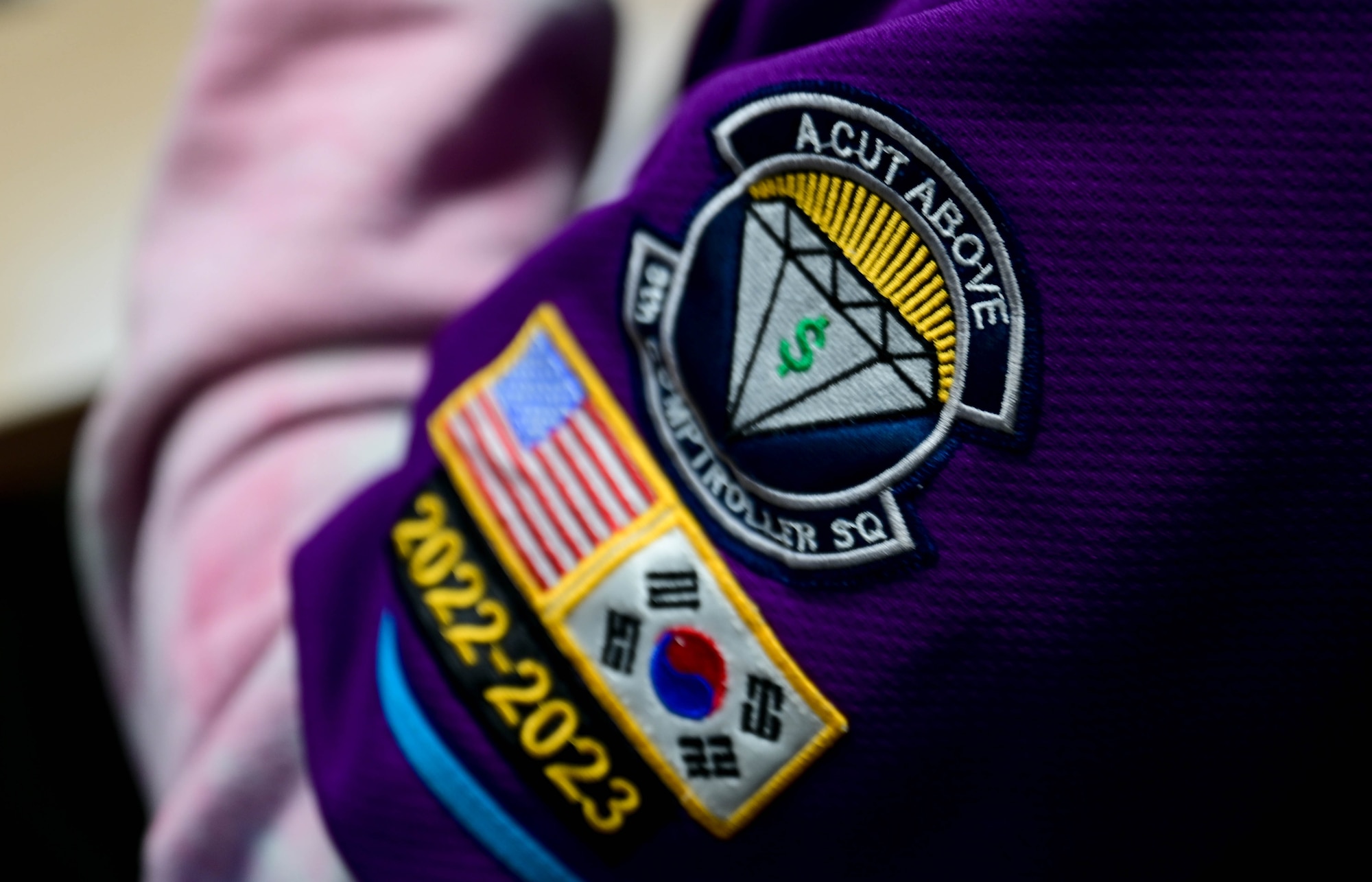 Senior Airman Calvin Cook, 8th Comptroller Squadron financial operations technician, displays his unit patch at Kunsan Air Base, Republic of Korea, Feb. 23, 2023.