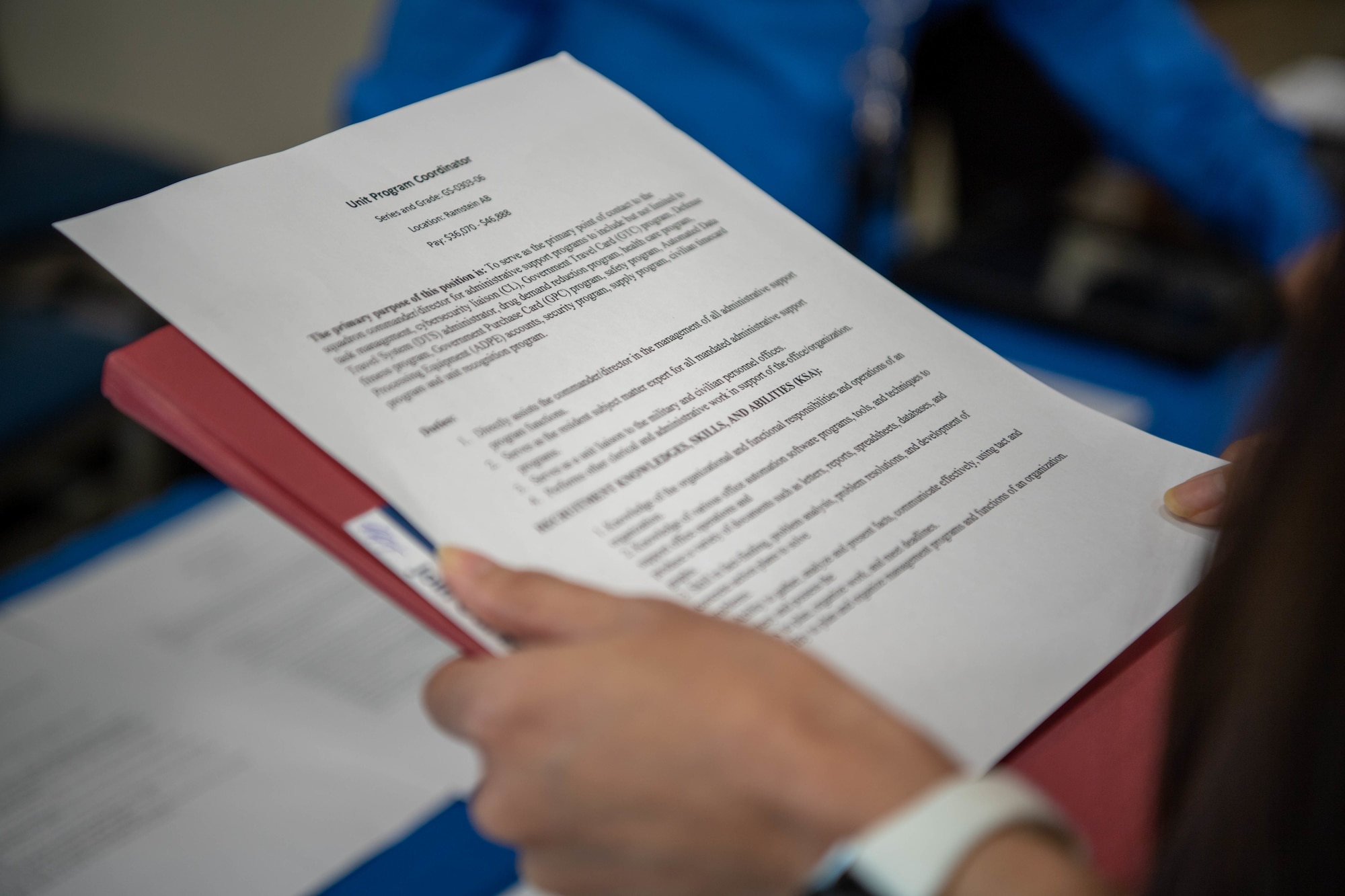 A military spouse carries a copy of their resume during a job fair at Ramstein Air Base, March 3, 2023.
