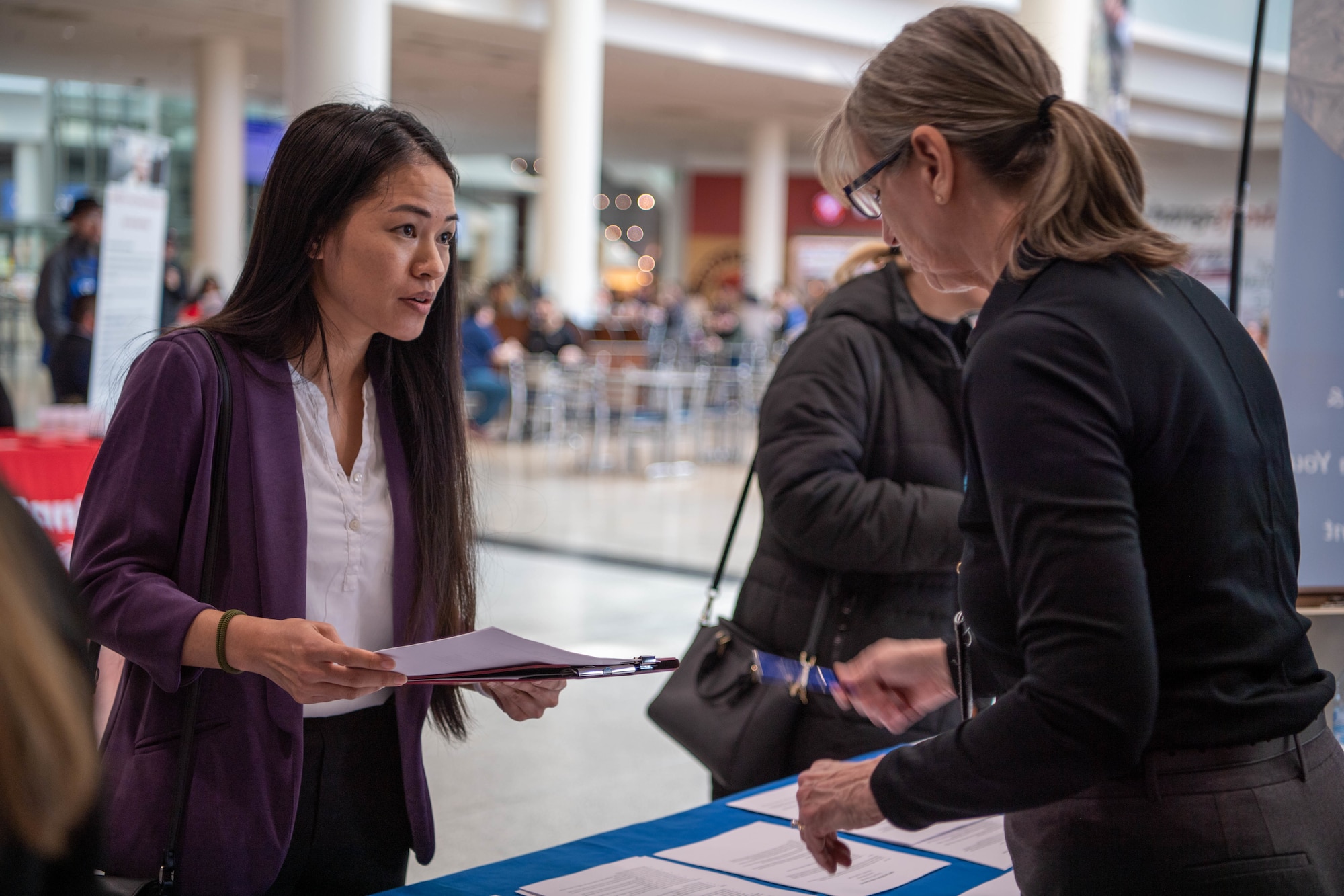 military spouse looks over current positions available under the Direct Hiring Authority program at a job fair held at Ramstein Air Base, March 3, 2023.