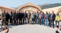 Brigadier Gen. Andrew T. Priddy, commanding general, Task Force 61/2, leadership from Task Force 61/2, and members of the Turkish Ministry of Health pose for a photo at Antakya, Türkiye, March 2, 2023. At the request of the Turkish government, U.S. military personnel assigned to Task Force 61/2 and 39th Air Base Wing were tasked with building a field hospital for the citizens who were affected by the Feb. 6 earthquakes. Upon completion of their efforts on March 2, 2023, leaders from Task Force 61/2 (TF 61/2), and 39th Air Base Wing conducted a final walk-through before the Turkish Ministry of Health began operations at the field hospital.