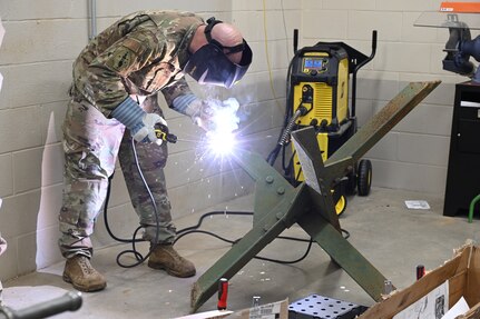 U.S. Air Force Staff Sgt Badders, 175th Wing Civil Engineering Squadron member, welds a steel structure at Martin State Air National Guard Base, Middle River, Maryland, March 2, 2023.  Badders was building a hedgehog barrier as part of Operation Lucky Strike 2023.