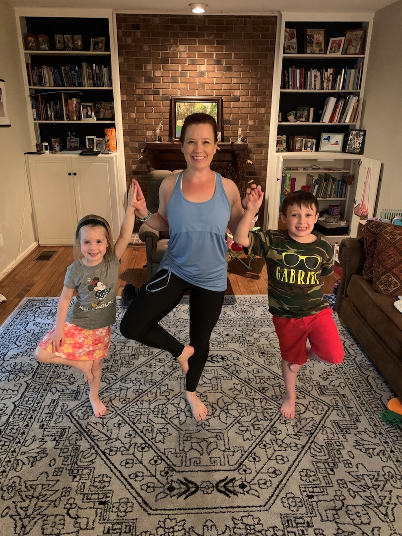 Allyson Conroy (center) and her children, AnnaBelle (left) and Gabriel (right) hold tree pose together, May 27, 2020. Conroy is a 500 hour yoga instructor trained in children’s yoga and trauma informed yoga. (Photo by Chief Warrant Officer Lee Conroy)