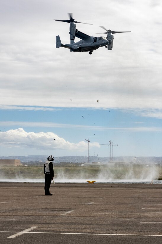 U.S. Marine Corps Sgt. Edgar Martinez Torres, a tiltrotor mechanic with Marine Medium Tiltrotor Squadron (VMM) 163, Marine Aircraft Group 16, 3rd Marine Aircraft Wing, watches as an MV-22B Osprey prepares to land in the staging area at National City Pier