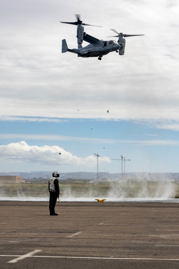U.S. Marine Corps Sgt. Edgar Martinez Torres, a tiltrotor mechanic with Marine Medium Tiltrotor Squadron (VMM) 163, Marine Aircraft Group 16, 3rd Marine Aircraft Wing, watches as an MV-22B Osprey prepares to land in the staging area at National City Pier in San Diego, Feb. 24, 2023. The squadron staged the aircraft for sea transport to provide task organized aviation combat elements and support. Martinez Torres is a Denver native. (U.S. Marine Corps photo by Lance Cpl. Courtney A. Robertson)