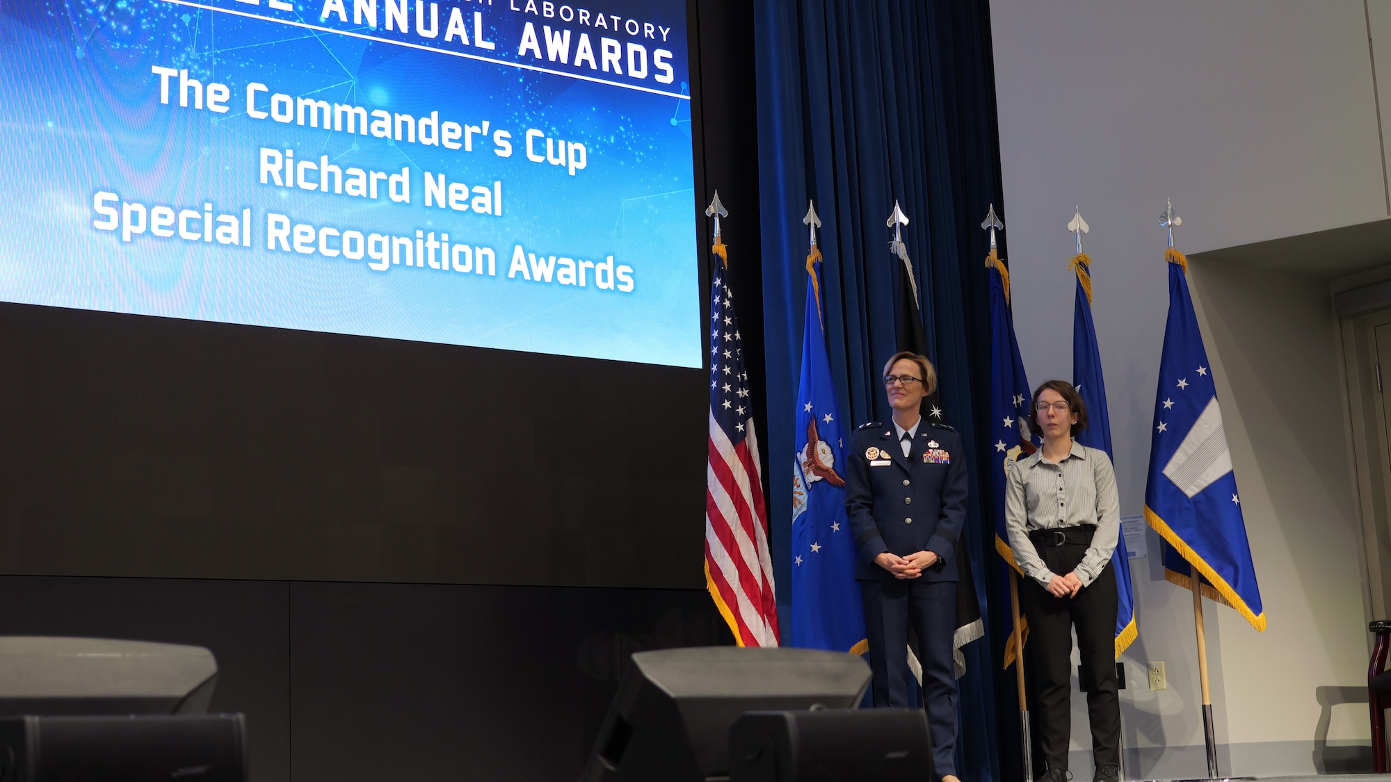 Maj. Gen. Heather Pringle, Air Force Research Laboratory, or AFRL, commander and Abby Neal, Richard Neal’s daughter, present the Commander’s Cup Richard Neal Special Recognition Awards at the 2022 AFRL Annual Awards Ceremony at the Air Force Institute of Technology's Kenney Hall at Wright-Patterson Air Force Base, Ohio, March 2, 2023. The Richard Neal Special Recognition Awards recognize employees unable to compete in other award categories due to the sensitive nature of their work. (U.S. Air Force photo / Keith Lewis)