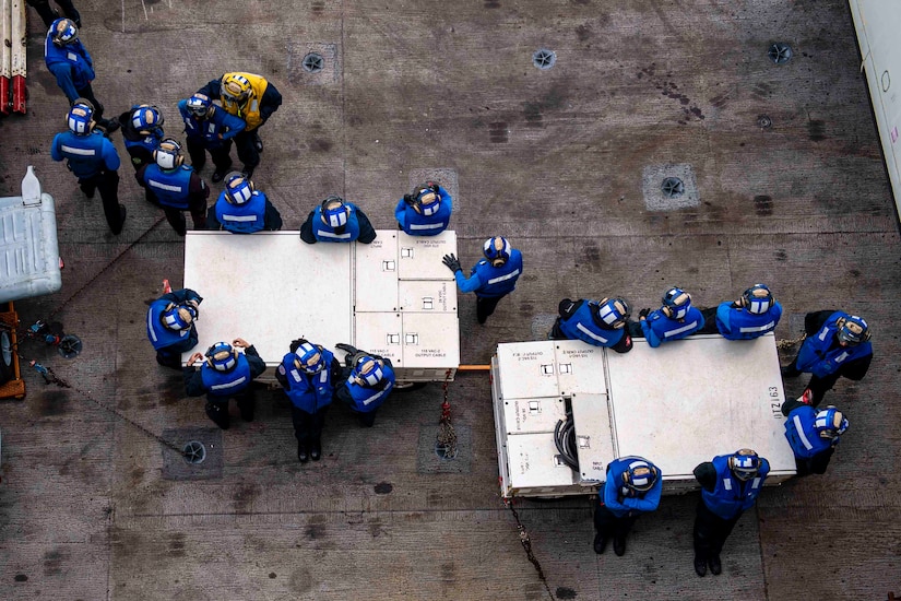 A look from above as sailors stand around equipment.