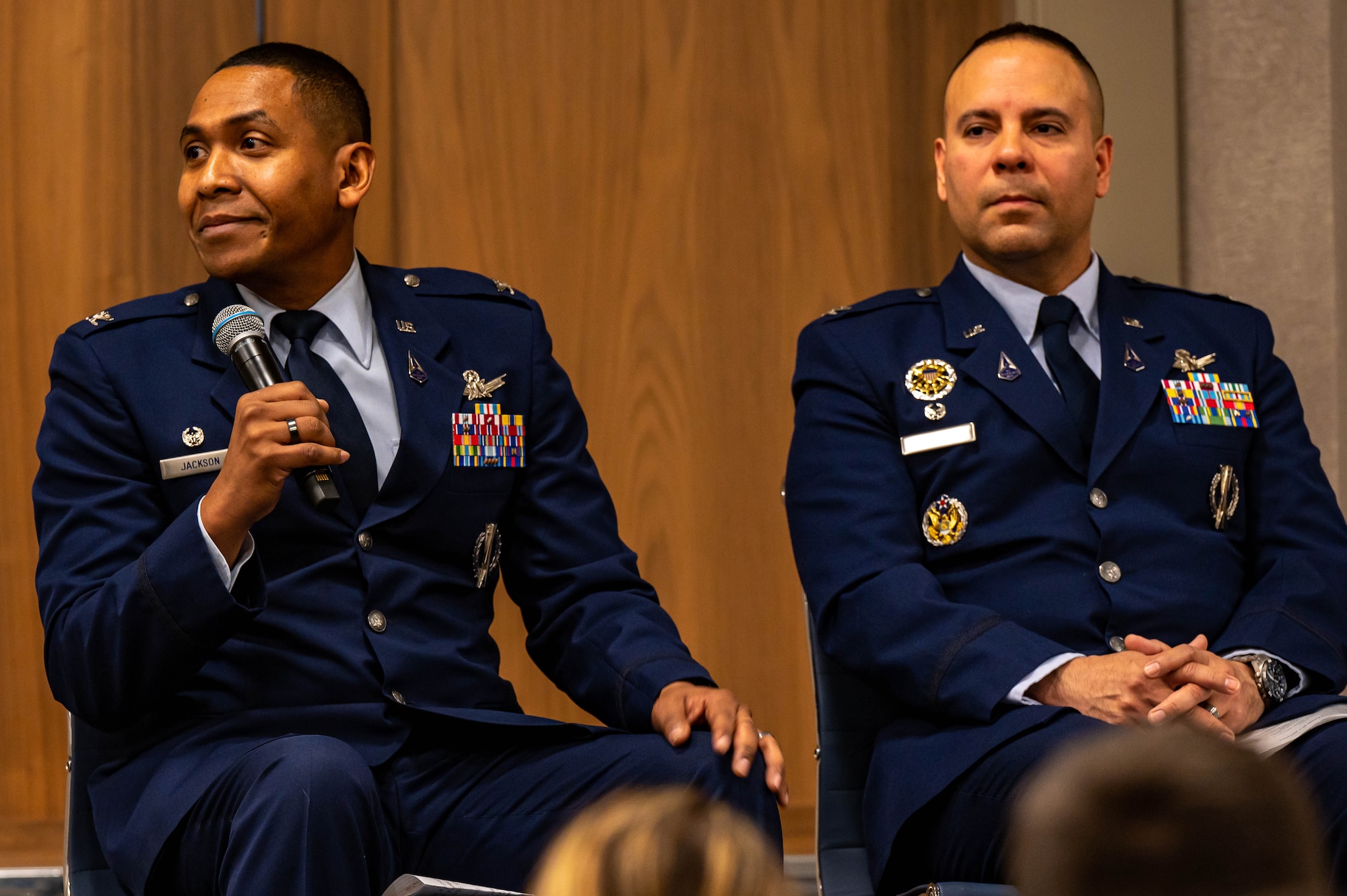 Two men sit and talk.