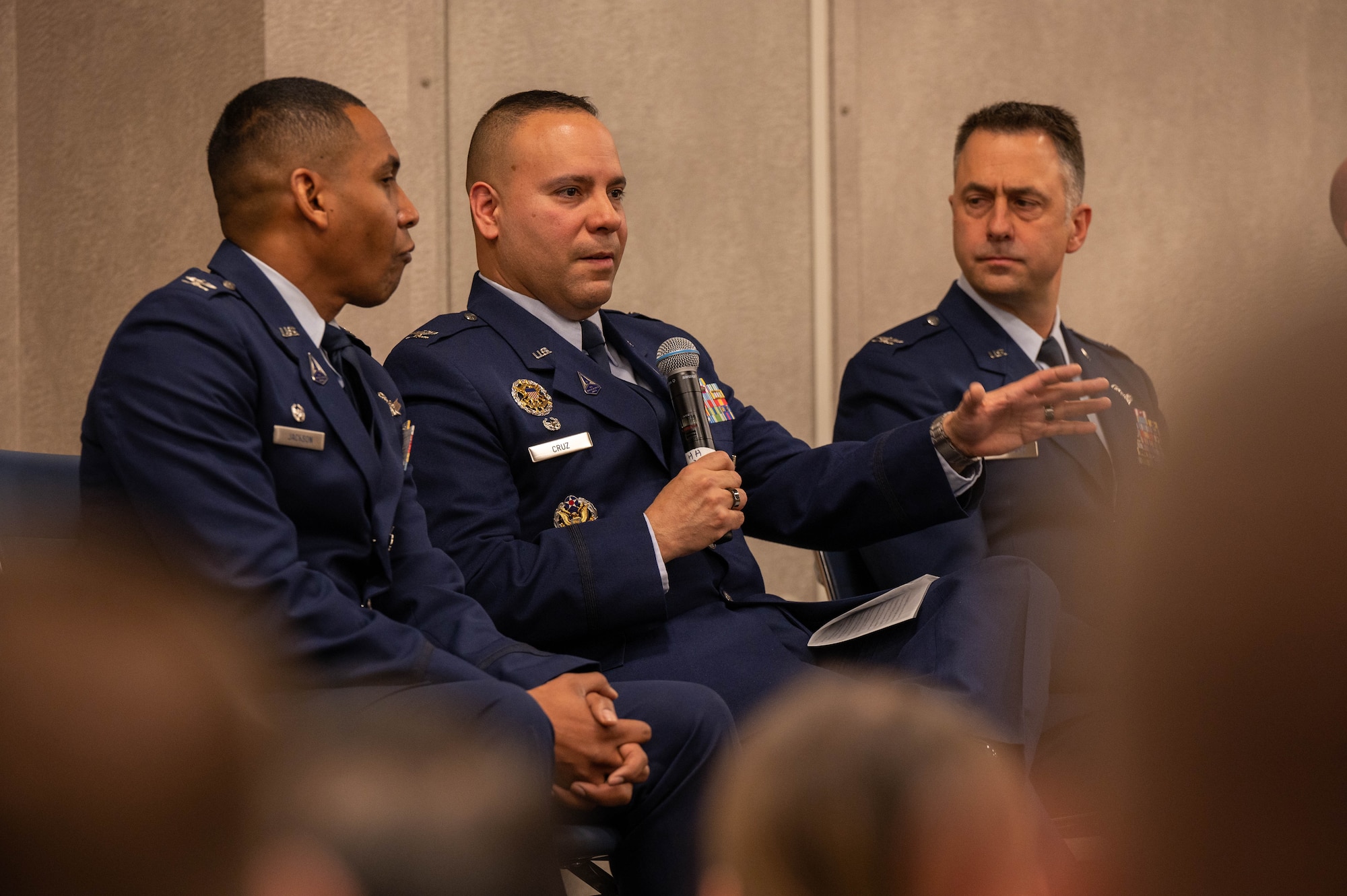 Three men sit and talk.