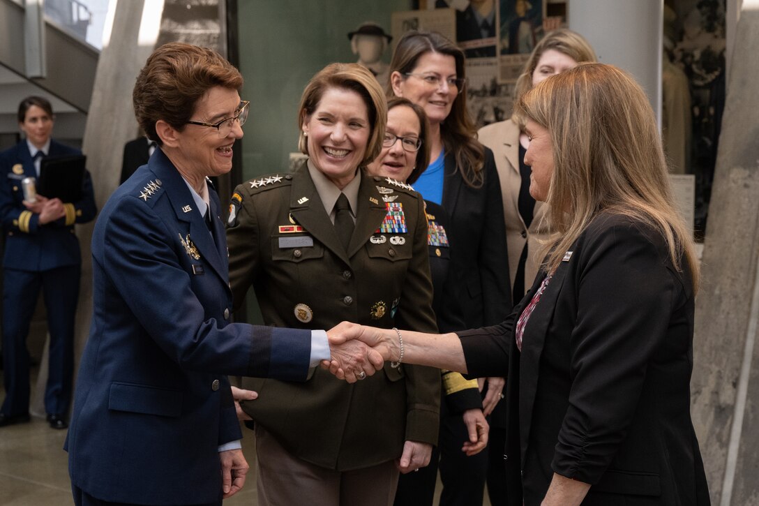 U.S. Air Force Gen. Jacqueline Van Ovost, U.S. Transportation Command commander, left, and U.S. Army Gen. Laura Richardson, U.S. Southern Command commander, greet attendees before a Women's History Month panel discussion at the Military Women's Memorial in Arlington National Cemetery, Arlington, Va., March 6, 2023.