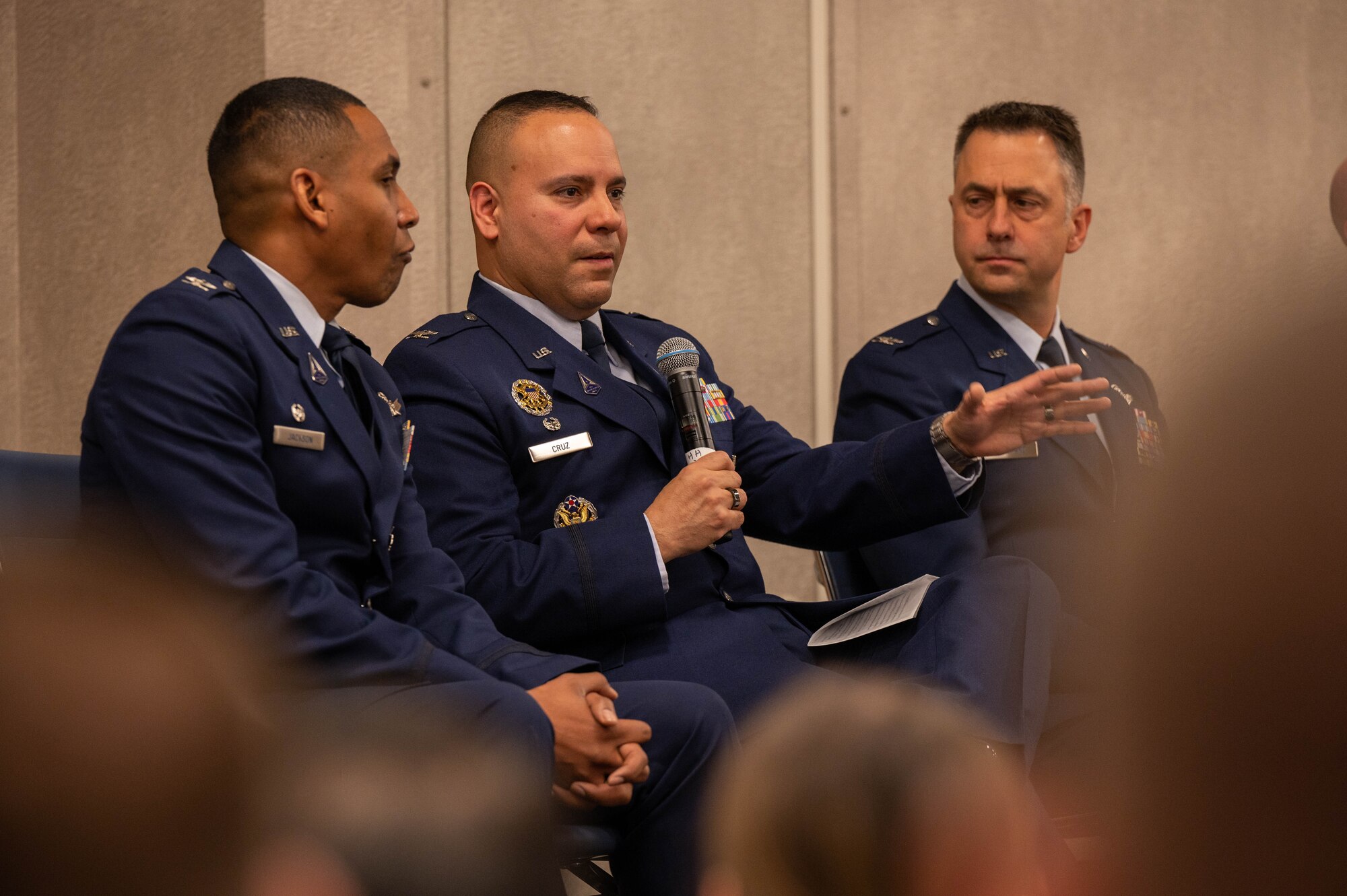 Three men sit and talk.