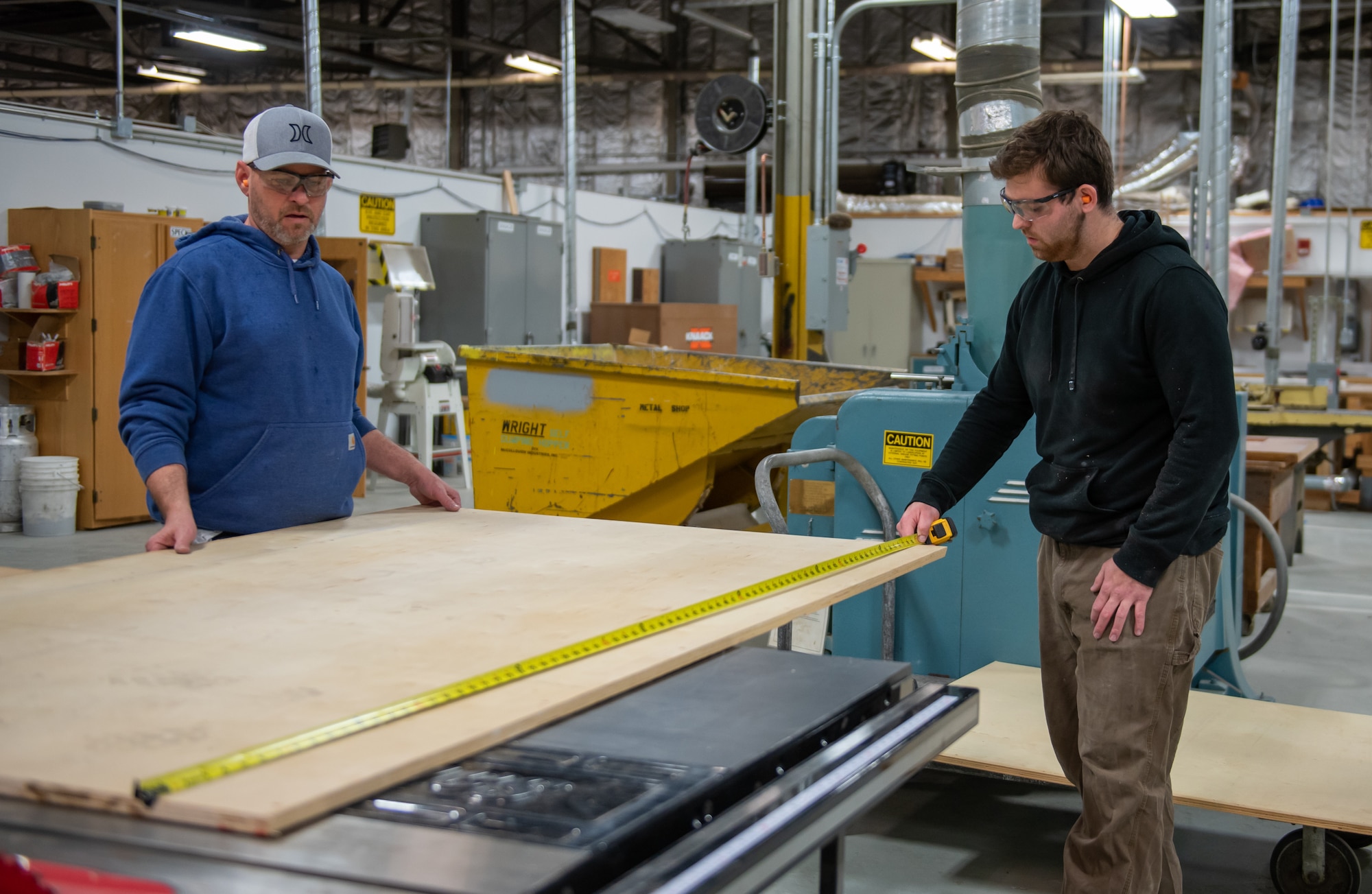 Jake Fletcher (right) and Sean Speck, 88th Civil Engineer Squadron carpenters, measure a piece of plywood to build a storage cabinet at Wright-Patterson Air Force Base, Ohio, Feb. 16, 2023. Fletcher has worked at Wright-Patt for nearly four years after beginning his career as a 17-year-old apprentice while attending Miami Valley Career Technology Center's construction carpentry program. (U.S. Air Force photo by Matthew Clouse)