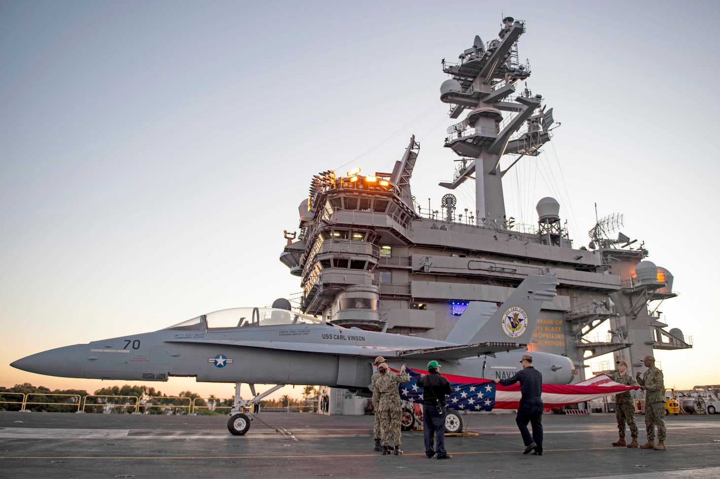 221116-N-OL611-1015 SAN DIEGO (Nov. 16, 2022) Sailors assigned to Nimitz-class aircraft carrier USS Carl Vinson (CVN 70) fold the national ensign after evening colors on the flight deck. Vinson is currently pierside in its homeport of San Diego. (U.S. Navy photo by Mass Communication Specialist 2nd Class Tyler Wheaton)