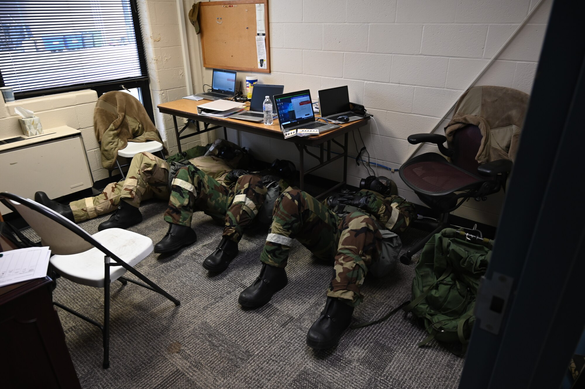 Airmen assigned to the 175th Financial Management team shelter under a table in the aerial port at Martin State Air National Guard Base, Middle River, Maryland, March 3, 2023.