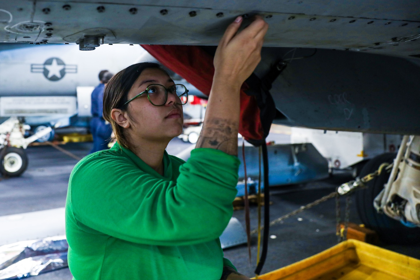 221212-N-PA221-2034 PACIFIC OCEAN (Dec. 12, 2022) U.S. Navy Aviation Structural Mechanic Safety Equipment 2nd Class Adane Ramos, from Dallas, installs panels on an E/A-18G Growler in the hangar bay aboard the aircraft carrier USS Nimitz (CVN 68). Nimitz is underway conducting routine operations. (U.S. Navy photo by Mass Communication Specialist 3rd Class Kevin Tang)