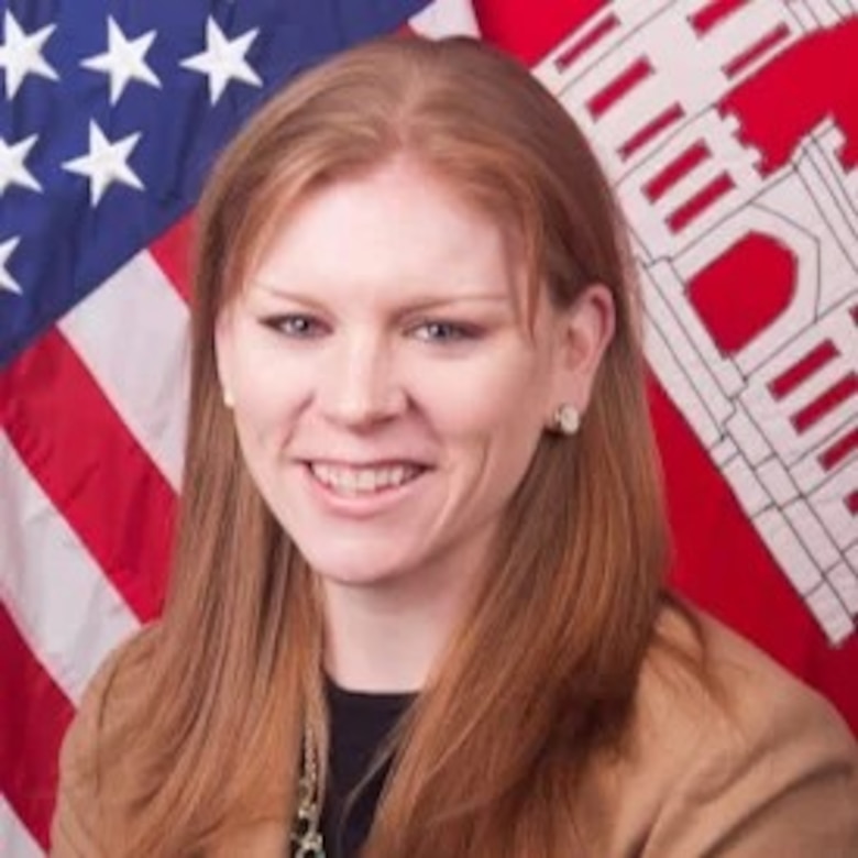 Kathleen Miller is pictured in front of an American flag backdrop.