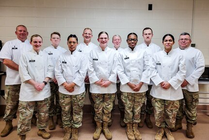 Iowa and Rhode Island National Guard Soldiers pose for a photo during the 47th Joint Culinary Training Exercise at Fort Lee, Virginia, March 5, 2023. The Soldiers made history by being part of the first Army National Guard team to participate in the  largest military culinary event in North America.