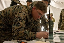 U.S. Marine Corps Sgt. James Lovitz, a combat engineer with 8th Engineer Support Battalion, Combat Logistics Regiment 27, 2nd Marine Logistics Group, plots damage points on a map during airfield damage repair training as part of Exercise Winter Pioneer 23 on Marine Corps Outlying Field Atlantic Oak Grove, Atlantic, North Carolina, Feb. 1, 2023. Winter Pioneer 23 is a tactical level exercise demonstrating integrated U.S. Marine Corps Engineer and U.S. Navy Construction units to establish and sustain an advanced naval base, expeditionary advanced bases, and contribute to maritime domain awareness. (U.S. Marine Corps photo taken by Lance Cpl. Jessica J. Mazzamuto)