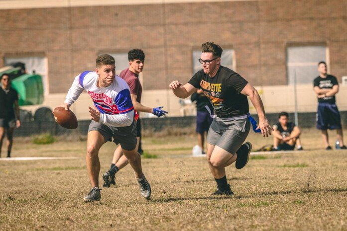 A U.S. Marine with 2nd Marine Logistics Group (2nd MLG), avoids the defense during a flag football tournament on Camp Lejeune, North Carolina, Feb. 24, 2023. 2nd MLG Marines participated in the commander’s cup to promote unit cohesion, esprit de corps, and physical fitness. (U.S. Marine Corps photo by Cpl. Meshaq Hylton)