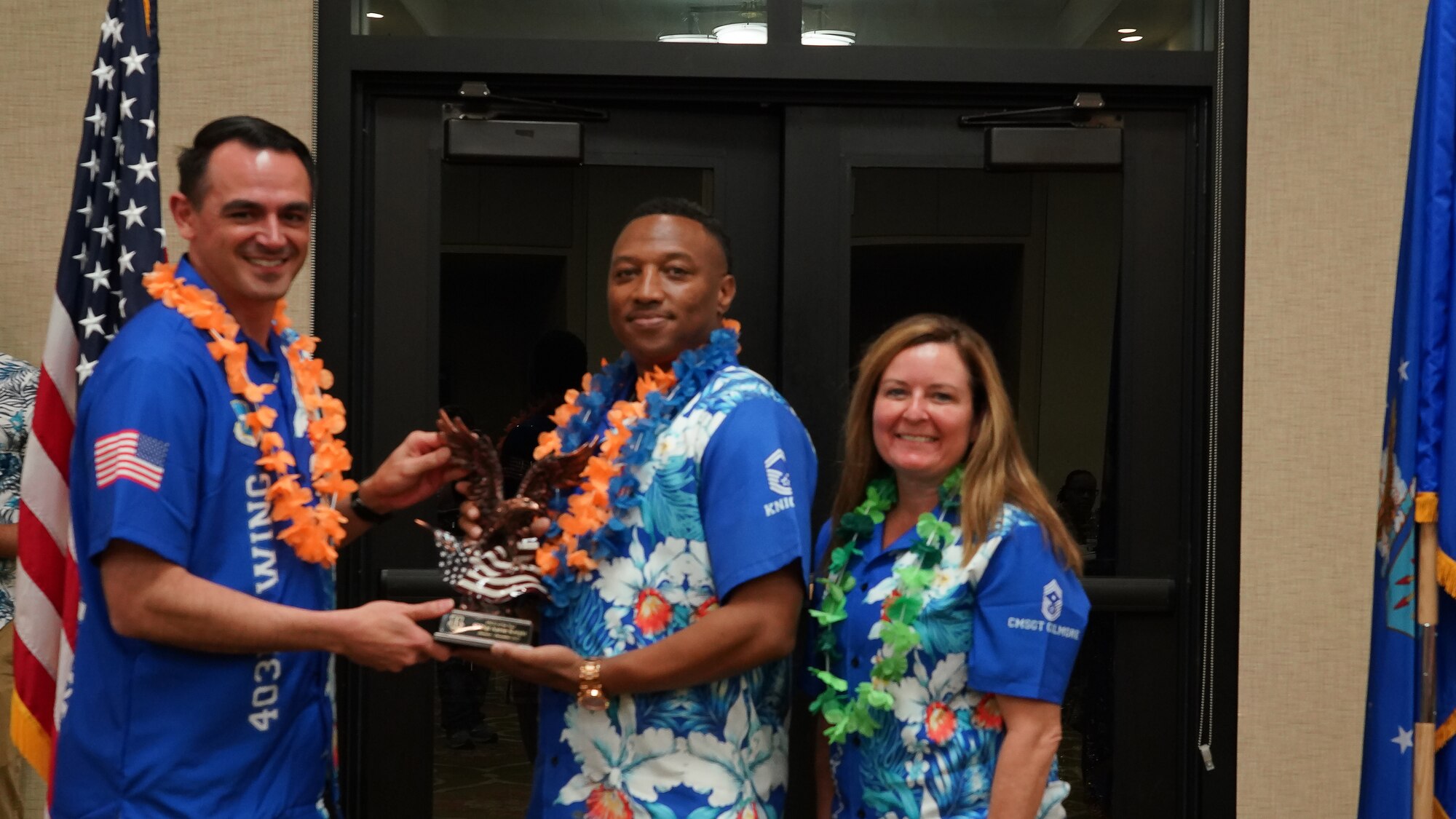 Col Rubio hands Senior Master Sgt. Knight a trophy. Chief Gilmore stands to the side.