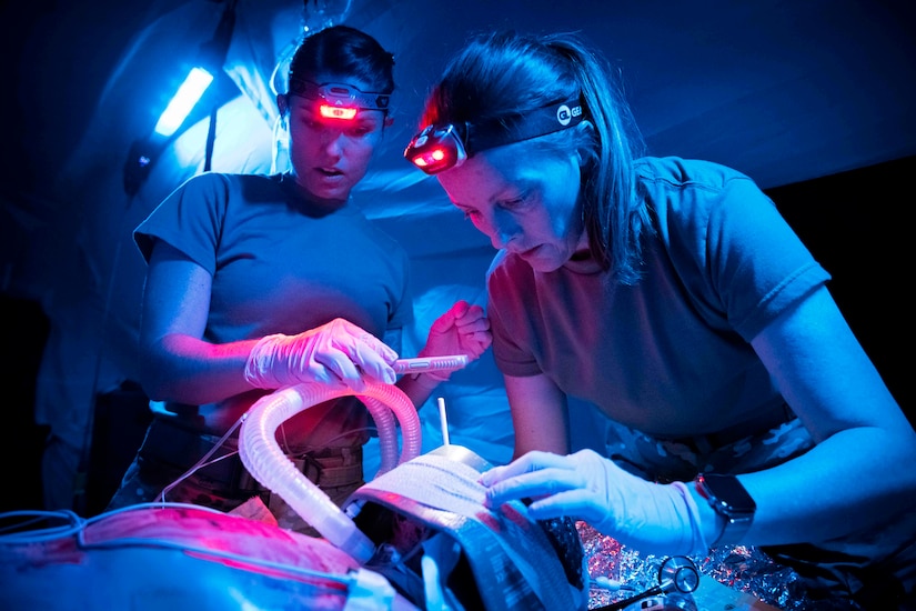 Physicians practice training on a medical mannequin.