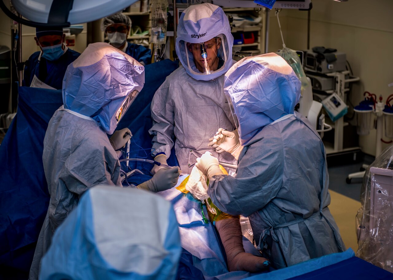 Surgeons work on patient in an operating room.
