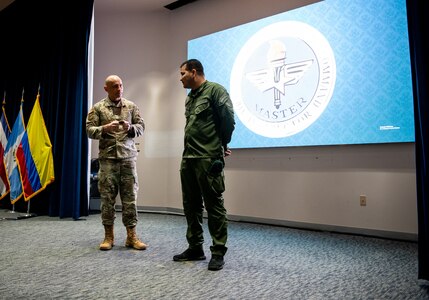 Col. José Jimenez, Jr., Commandant of the Inter-American Air Forces Academy, holds speaks to Intendente Jefe Alexander Pacheco of Colombia’s National Police, at JBSA-Lackland, Texas, Feb. 17, 2023. Pacheco, a partner nation guest instructor at IAAFA, recently earned the Air Education Training Command Master Instructor designation. He is the first international member to earn master instructor, which is the highest honor one can earn as an instructor. (U.S. Air Force photo by Vanessa R. Adame)