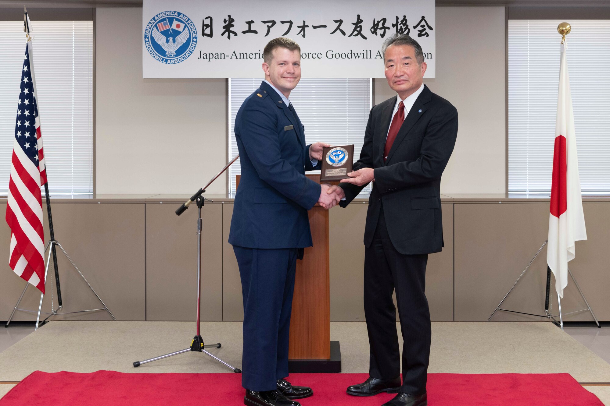 Maj. Lance Mazzella, 374th Logistics Readiness Squadron director of operations, accepts the Japan-America Air Force Goodwill Association Award plaque from Yoshiyuki Sugiyama, JAAGA president, during a ceremony at Yokota Air Base, Japan, March 3, 2023