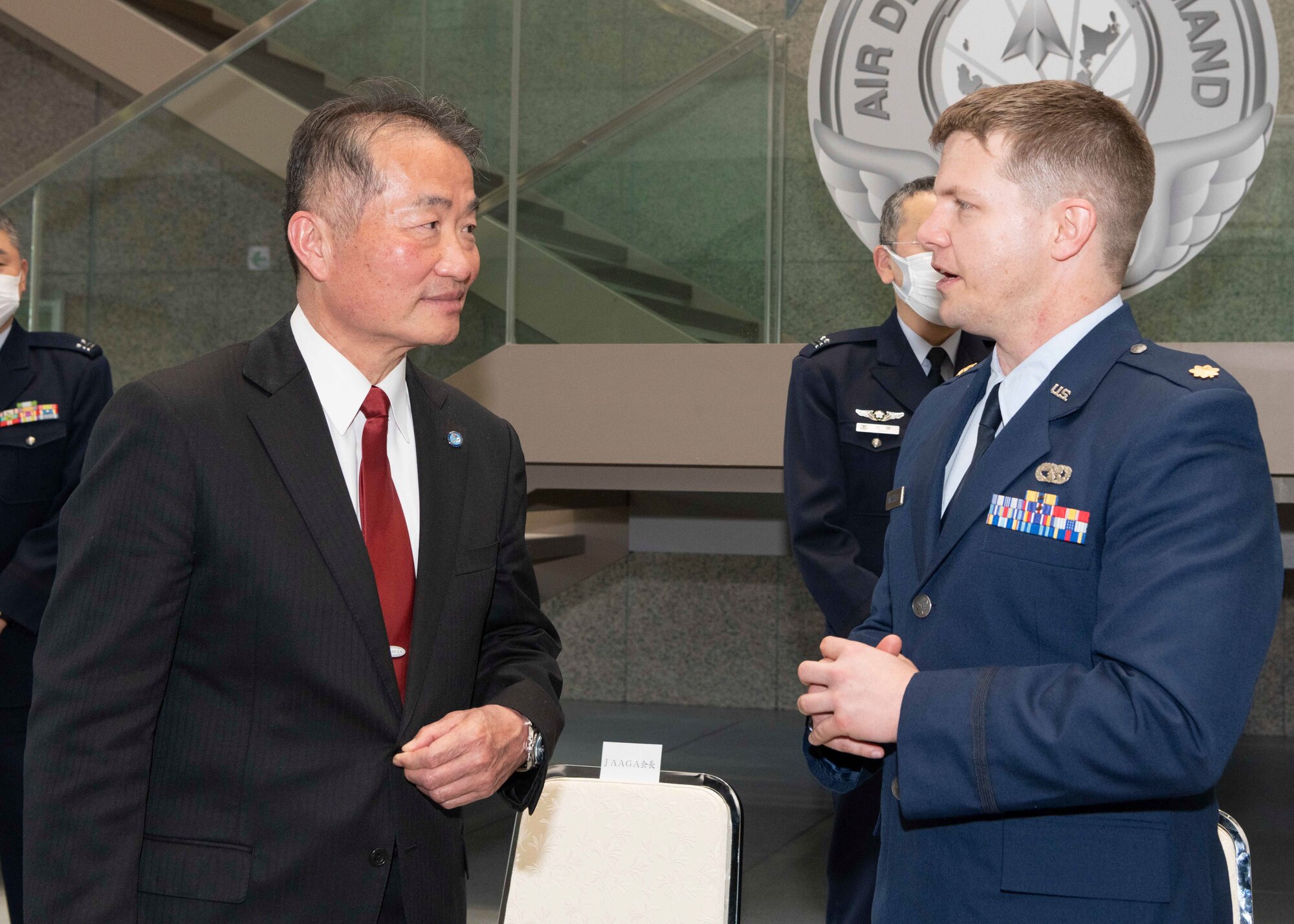 Maj. Lance Mazzella, 374th Logistics Readiness Squadron director of operations, speaks with Yoshiyuki Sugiyama, Japan-America Air Force Goodwill Association president, during the JAAGA Awards ceremony at Yokota Air Base, Japan, March 3, 2023.