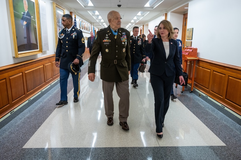 A retired soldier walks with the deputy defense secretary in the  halls of the Pentagon.