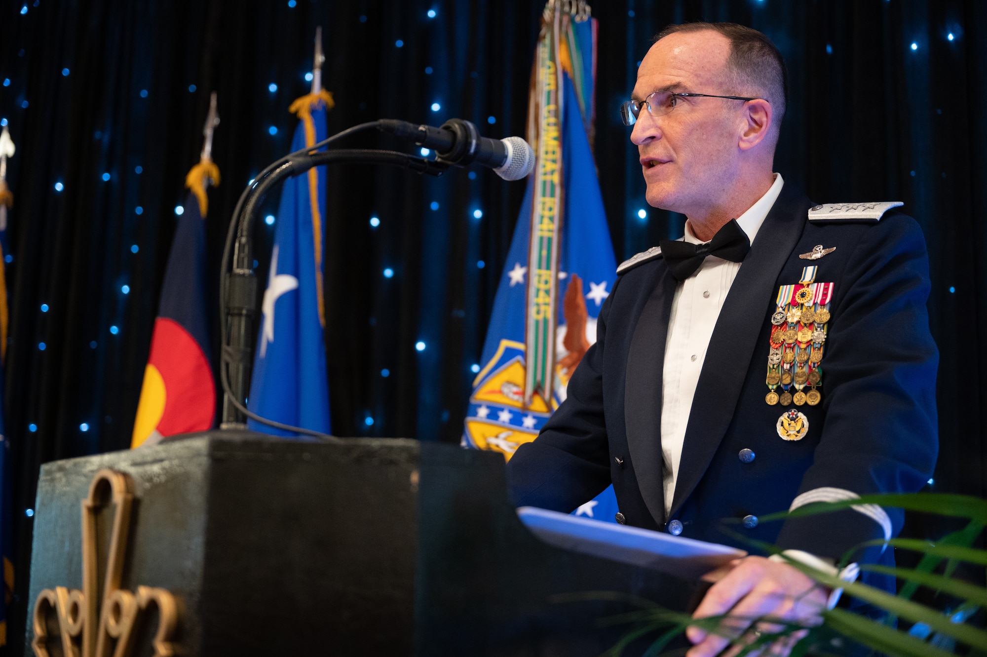 A person standing behind a podium speaks into a microphone.