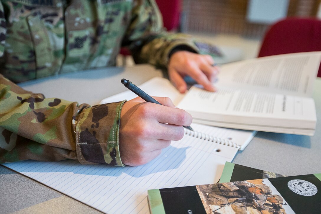 Service member prepares to write in a notebook.